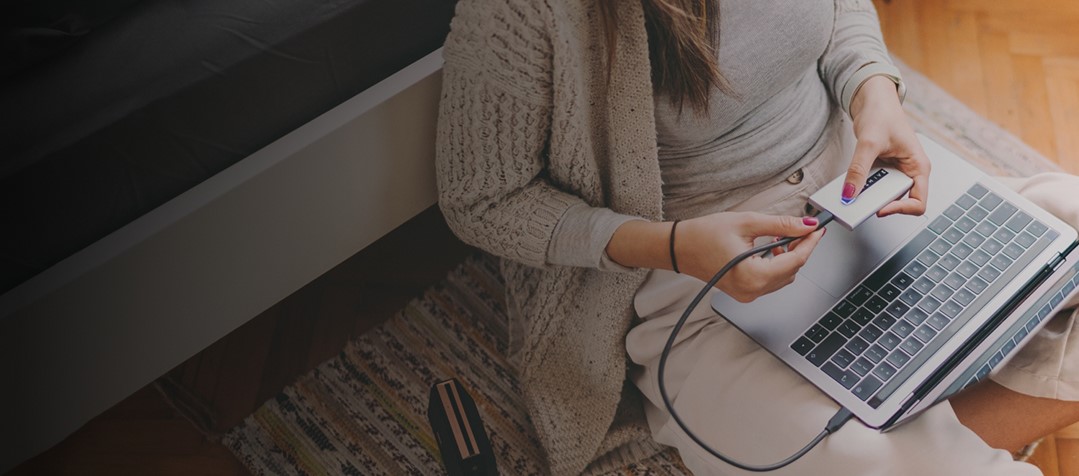 Frau erstellt manuell ein Backup von ihrem Laptop auf eine externe Festplatte